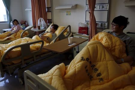 Hsu Bi-chi and her sons Chang Chun-po and Chang Chun-jung (L-R) rest at a hospital after an earthquake hit Tainan, southern Taiwan February 8, 2016. REUTERS/Tyrone Siu