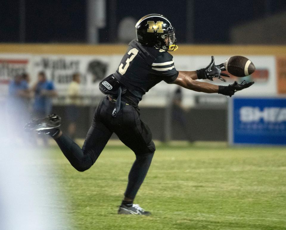 Milton's Kaiden Hall No. 3) pulls in the pass for a huge gain against the Gulf Breeze defense during Friday night's gridiron action.