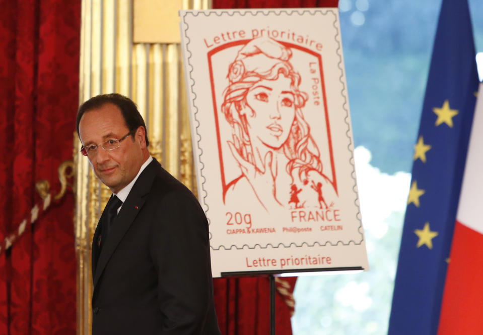 FILE - In this Sunday, July 14, 2013 file photo French President Francois Hollande stands next to the newly unveiled official Marianne postage stamp at the Elysee Palace during the Bastille Day celebrations in Paris. The new face of France _ or at least the official postage stamp for the President Francois Hollande era _ is modeled after a Ukrainian woman who takes her top off to defend feminist causes. Not everyone thinks that’s appropriate. The small, conservative Christian Democrat Party is calling for a boycott of the stamp. Hollande on Sunday unveiled the new stamp, meant to represent Marianne, a symbol of France since the revolution. Afterward, the artist said the image was modeled largely after Femen activist Inna Shevchenko. (AP Photo/Francois Mori, File)