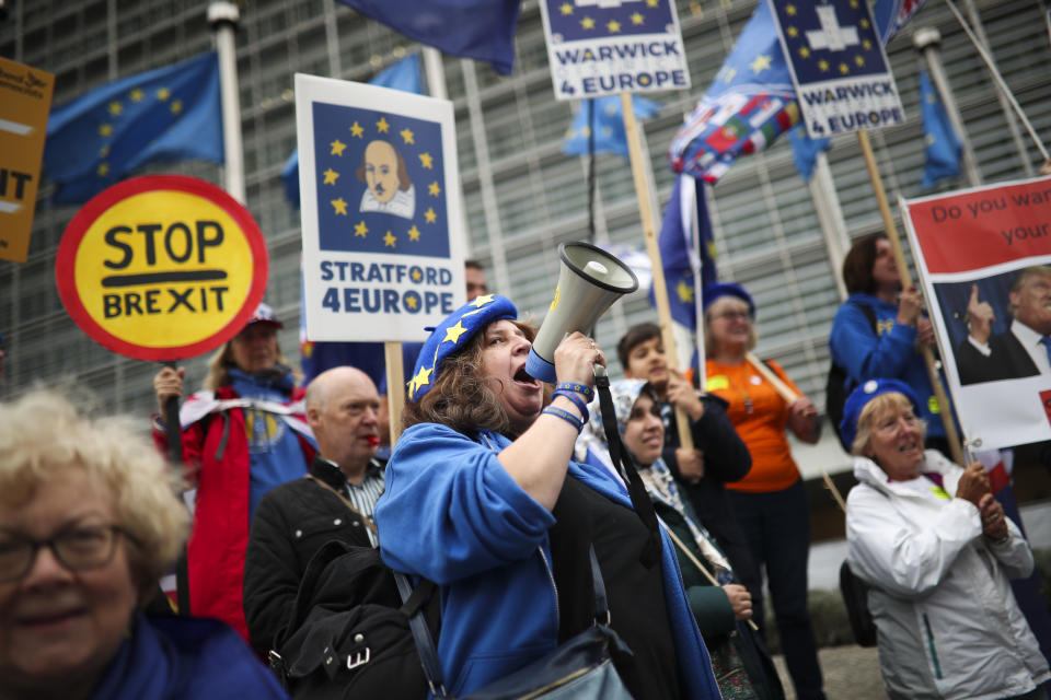 People shout slogans during an anti-Brexit protest outside the European Commission headquarters in Brussels, Wednesday, Oct. 9, 2019. A small group of anti-Brexit campaigners has staged a protest at the European Commission's headquarters in Brussels asking for a rejection of British Prime minister Boris Johnson's proposals for his country's planned exit from the bloc. (AP Photo/Francisco Seco)