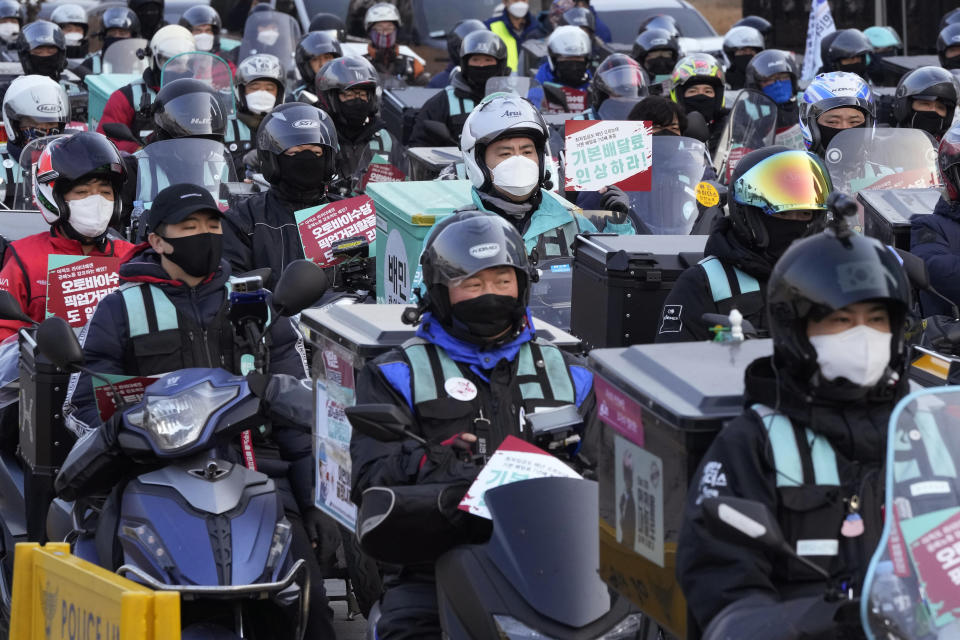 Food delivery riders wearing face masks to help protect against the spread of the coronavirus stage a rally to demand better working conditions in Seoul, South Korea, Thursday, Dec. 23, 2021. South Korea has set a new record for daily COVID-19 deaths as it struggles to resolve a shortage of hospital beds amid weeks of surging cases. (AP Photo/Ahn Young-joon)