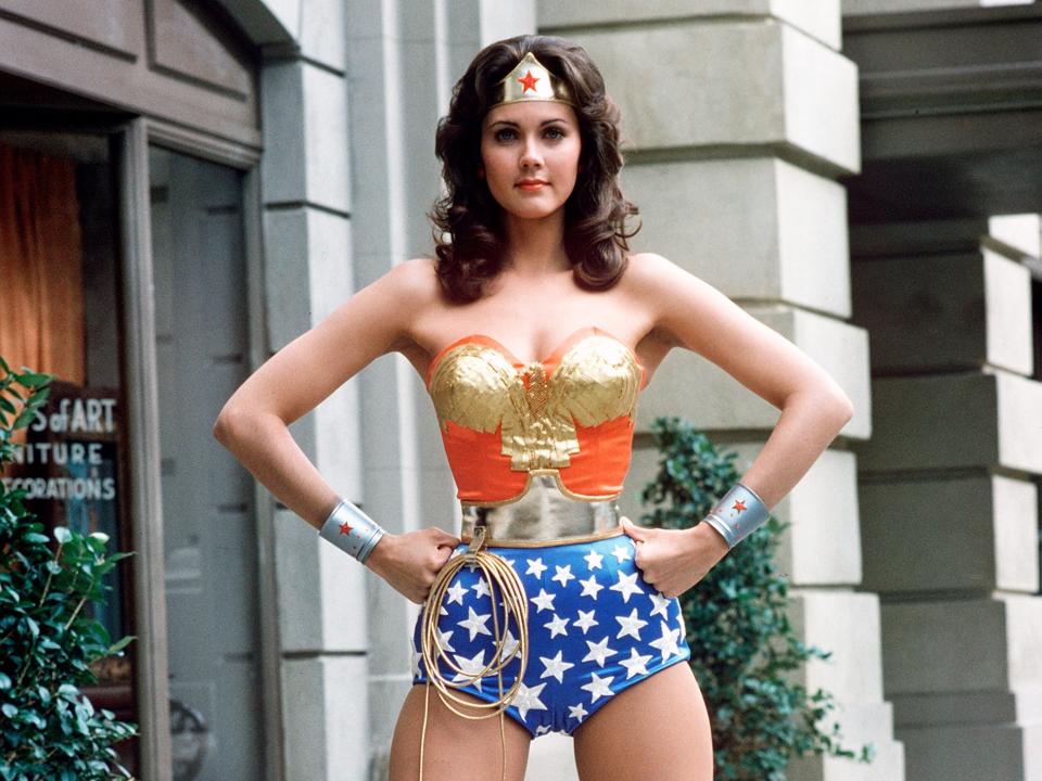 Lynda dressed in an American flag corset and short costume with a crown and lasso.