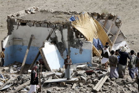 People gather on the wreckage of a house destroyed by an air strike in the Bait Rejal village west of Yemen's capital Sanaa April 7, 2015. REUTERS/Khaled Abdullah