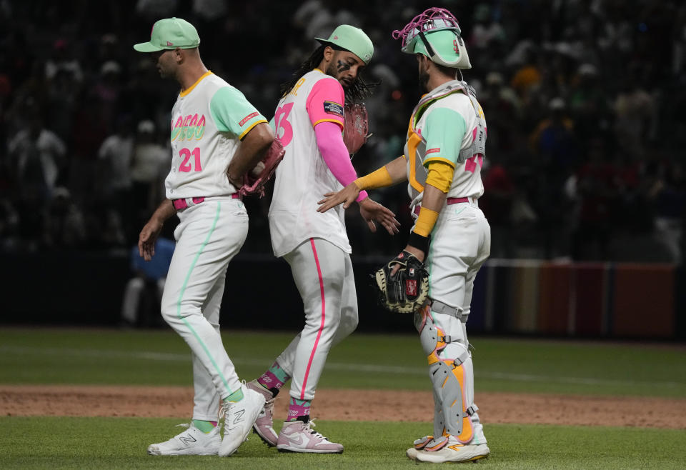San Diego Padres Fernando Tatis Jr., center, celebrates with his teammates Nick Martinez, left, and Brett Sullivan after their team's victory over San Francisco Giants during a baseball game in Mexico City, Saturday, April 29, 2023. (AP Photo/Fernando Llano)