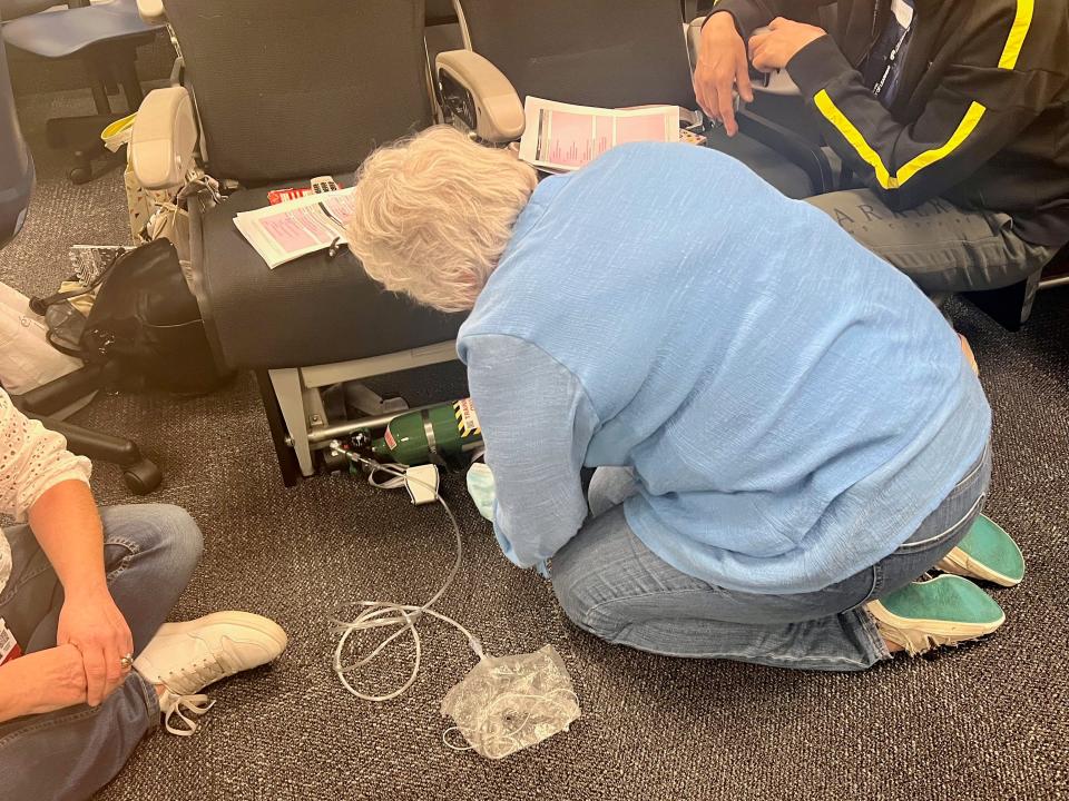 One of the trainees learning how to attach the oxygen tank to the seat — "It's all hands-on learning," she said. "We take them through all the equipment we have and they go around in groups to practice."