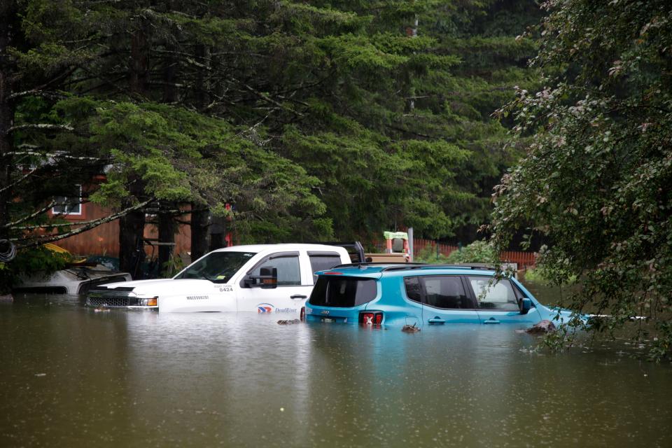 Floodwaters rise in Bridgewater, Vt., Monday, July 10, 2023, submerging parked vehicles and threatening homes near the Ottauquechee River. Heavy rain drenched part of the Northeast, washing out roads, forcing evacuations and halting some airline travel. (AP Photo/Hasan Jamali)