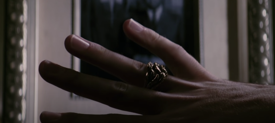 A woman looks at a ring on her finger