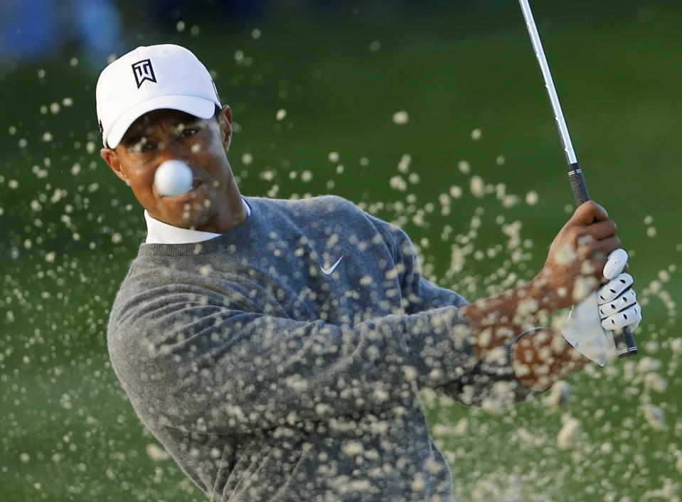 U.S. golfer Tiger Woods hits from a sand trap on the fifth hole during weather delayed fourth round play at the Farmers Insurance Open in San Diego, California January 27, 2013. REUTERS/Mike Blake (UNITED STATES - Tags: SPORT GOLF TPX IMAGES OF THE DAY) - RTR3D2HO