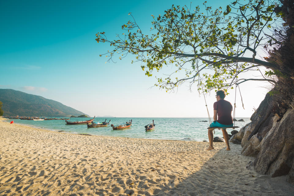 Un touriste assis sur une balançoire profite des plages de Thaïlande (Crédit : Getty Images)