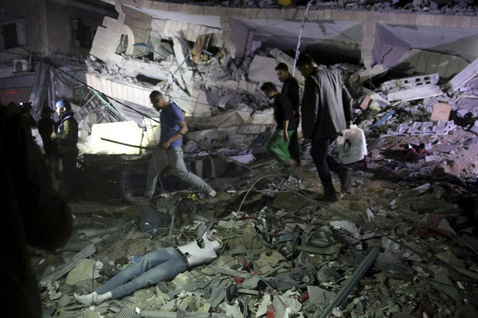 Owners of stores at the building inspect the damage of their destroyed multi-story building in Gaza City, Saturday, May 4, 2019. Palestinian militants on Saturday fired over 200 rockets into Israel, drawing dozens of retaliatory airstrikes on targets across the Gaza Strip in a round of intense fighting that broke a monthlong lull between the bitter enemies. Three Palestinians, including a mother and her baby daughter, were killed, while three Israelis, including an 80-year-old woman, were wounded by rocket fire. (AP Photo/Adel Hana)