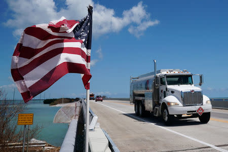 A truck delivering fuel passes a U.S. flag on a highway US 1 following Hurricane Irma in Islamorada, Florida, U.S., September 15, 2017. REUTERS/Carlo Allegri