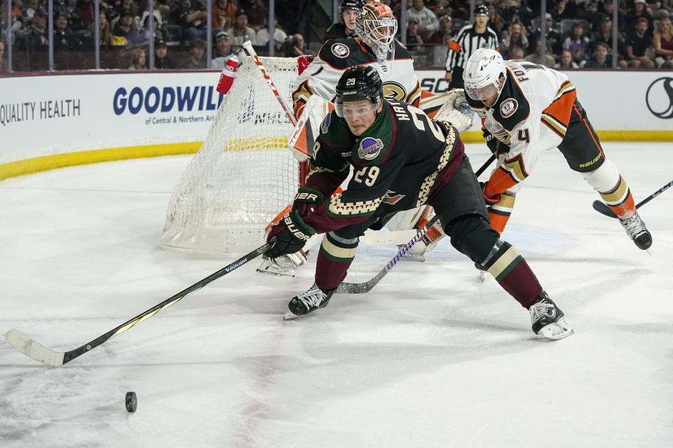 Arizona Coyotes' Barrett Hayton (29) chases down the puck against Anaheim Ducks' Cam Fowler (4) during the first period of an NHL hockey game Saturday, Oct. 21, 2023, in Tempe, Ariz. (AP Photo/Darryl Webb)