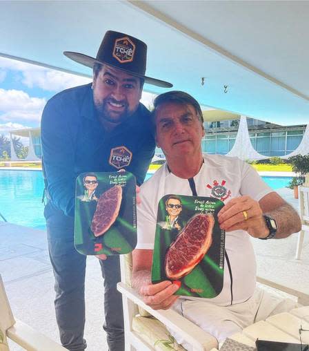 Bolsonaro posa ao lado do churrasqueiro Tch&#xea;, no Pal&#xe1;cio da Alvorada, segurando duas embalagens de Picanha Mito