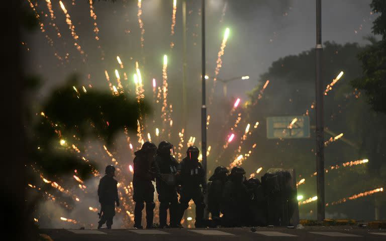 La policía antidisturbios confronta a los partidarios de Luis Fernando Camacho, una figura clave de la oposición y gobernador de la región de Santa Cruz, luego de su arresto, en Santa Cruz, Bolivia, el 28 de diciembre de 2022. (Rodrigo URZAGASTI / AFP)