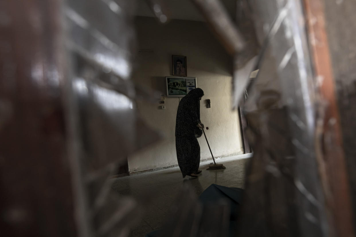 A Palestinian woman cleans her damaged house following an Israeli airstrike in Rafah, southern Gaza strip, Sunday, Aug. 7, 2022. Israel has killed two senior Islamic Jihad militants in three days of air strikes in the Gaza Strip, and Palestinian militants have launched nearly 600 rockets at Israel. Palestinian officials say at least 31 people in Gaza have died. (AP Photo/Fatima Shbair)