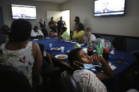 Malachi Keller, 15, right, leans back in an office chair while watching a Black History Month police promotional video during a meeting with police at One Police Plaza in New York on Monday, Aug. 24, 2020. Keller's cousin Sharawn Vinson sought the help of Jeffrey Maddrey, chief of the NYPD's Community Affairs department, after police officers pointed guns at her 11-year-old son when they were searching for a shooting suspect in their apartment building. (AP Photo/Jessie Wardarski)