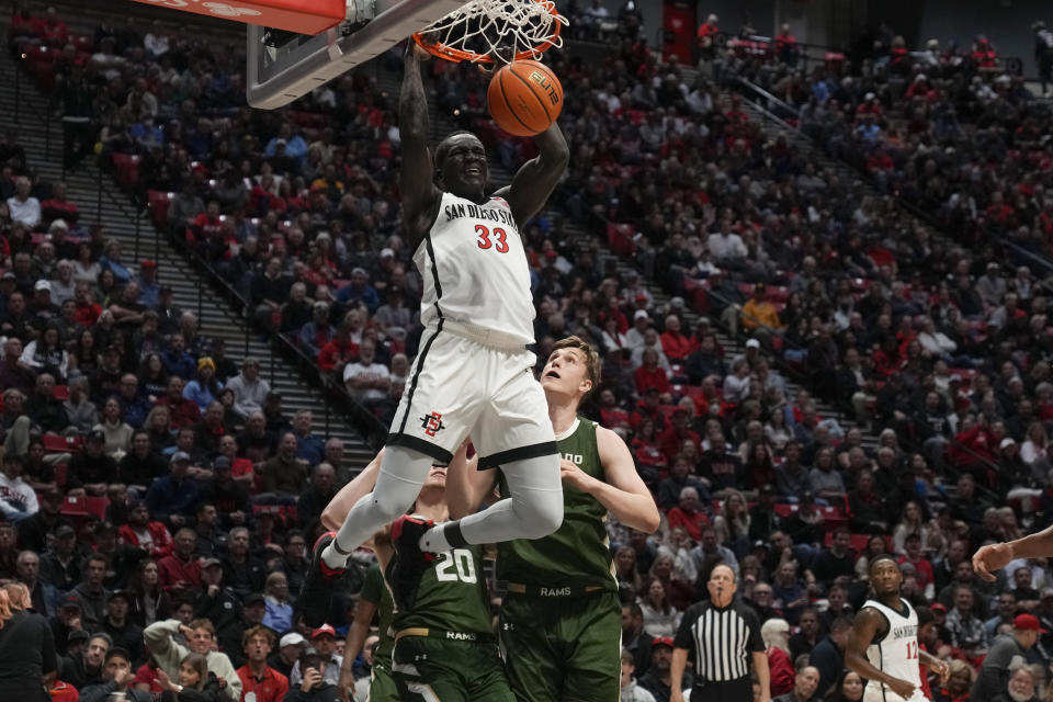 San Diego State forward Aguek Arop (33) dunks the ball as Colorado State forward James Moors, right, looks on during the first half of an NCAA college basketball game Tuesday, Feb. 21, 2023, in San Diego. (AP Photo/Gregory Bull)