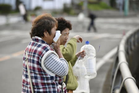 A woman cries as she looks at her collapsed house caused by an earthquake in Mashiki town, Kumamoto prefecture, southern Japan, in this photo taken by Kyodo April 17, 2016. Mandatory credit REUTERS/Kyodo