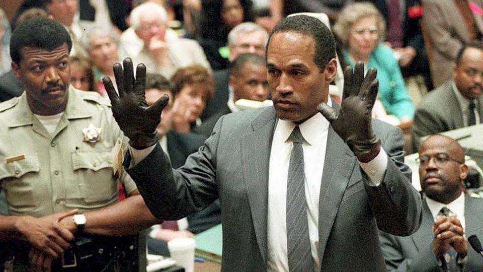 PHOTO: O.J. Simpson shows the jury a new pair of Aris extra-large gloves, similar to the gloves found at the Bundy and Rockingham crime scene June 21, 1995, during his double murder trial in Los Angeles. (Vince Bucci/POOL/AFP via Getty Images)