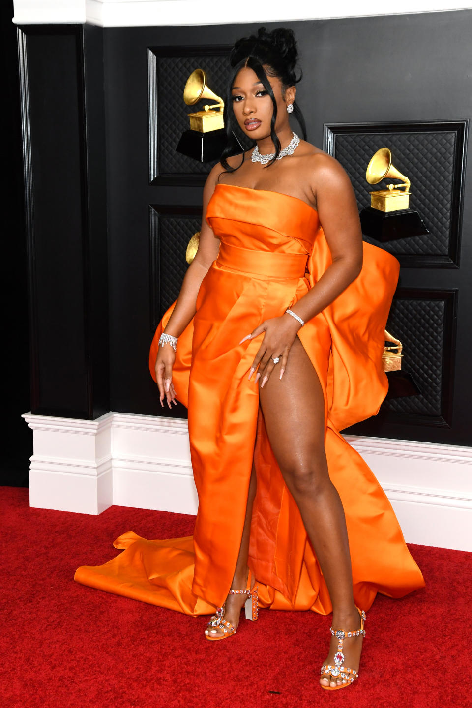 <p>Megan Thee Stallion verband Eleganz und Extravaganz in diesem sexy Dress von Dolce & Gabbana, das mit Beinschlitz, grellem Orange und riesigem Schleifendetail am Rücken eine moderne Variante der klassischen Abendrobe darstellte. (Bild: Kevin Mazur/Getty Images for The Recording Academy )</p> 