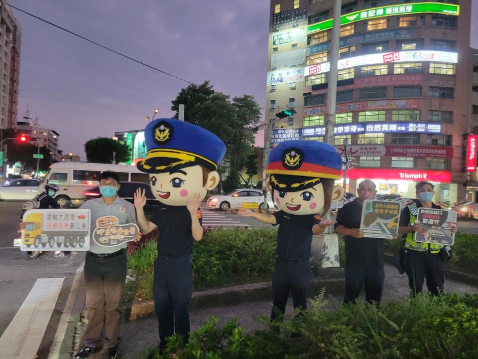 圖片說明：中市警二分局大頭娃娃現身宣導臺中市北區易肇事路口，要你平平又安安!(記者林㤈輝翻攝) 