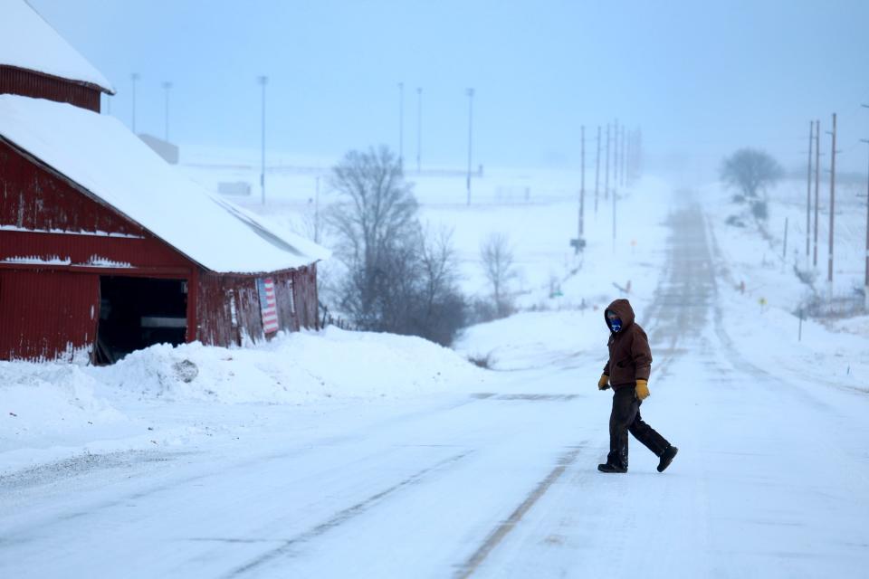 A person walks back to his home after checking the mailbox as a snowy and freezing cold weather system passes through the area on Jan. 13, 2024, in Casey, Iowa. The weather system brought snowfall and subzero temperatures to Iowa as caucusgoers prepare for the Republican presidential caucuses on Jan. 15.