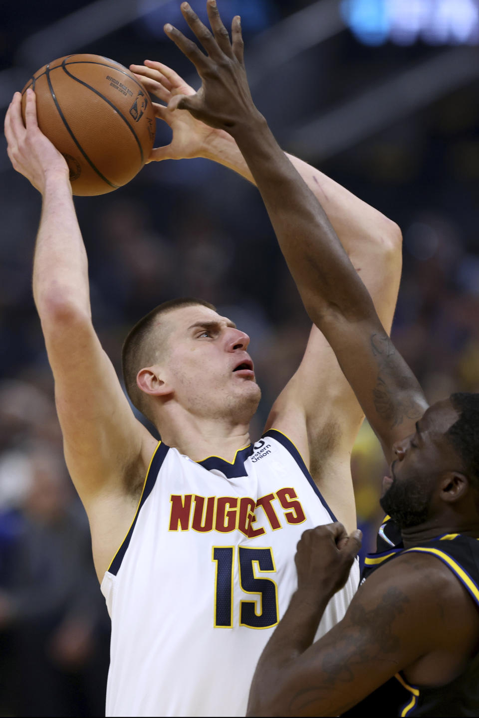 Denver Nuggets center Nikola Jokic (15) shoots against Golden State Warriors forward Draymond Green during the first half of Game 5 of an NBA basketball first-round playoff series in San Francisco, Wednesday, April 27, 2022. (AP Photo/Jed Jacobsohn)