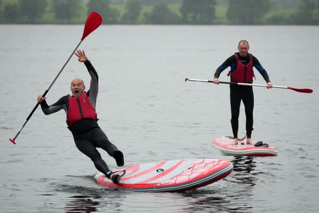 Liberal Democrat leader Ed Davey, left, enjoys some paddleboarding on Lake Windermere during a campaign stop in Windermere, England, on Tuesday, May 28.