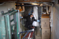 Funeral director Tom Cheeseman and a colleague wear personal protective equipment due to COVID-19 concerns after delivering a body to a funeral home, Friday, April 3, 2020, in the Brooklyn borough of New York. Cheeseman is picking up as many as 10 bodies per day. Most bodies come from homes and hospitals. (AP Photo/John Minchillo)