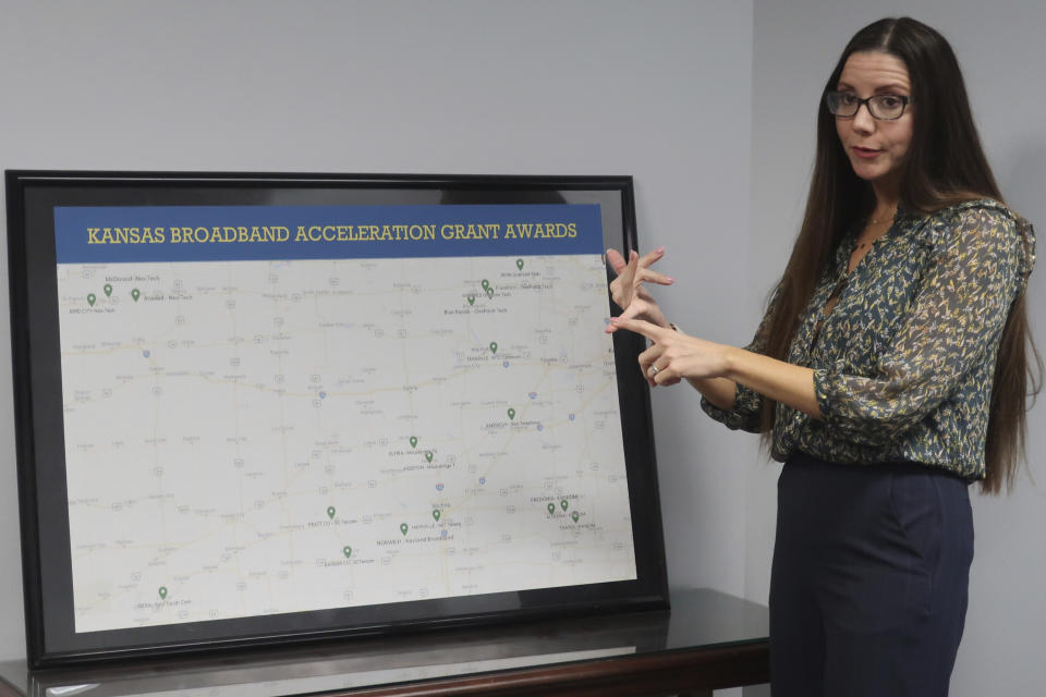 Jade Piros de Carvalho, director of the Office of Broadband Development in the Kansas Department of Commerce, discusses why communities need broadband internet service across the state while showing a map of state grants for projects, Wednesday Dec. 13, 2022, in the department's offices in Topeka, Kansas. States are facing a tight deadline for proposing corrections to the federal government's map that spells out which areas lack broadband service. (AP Photo/John Hanna)