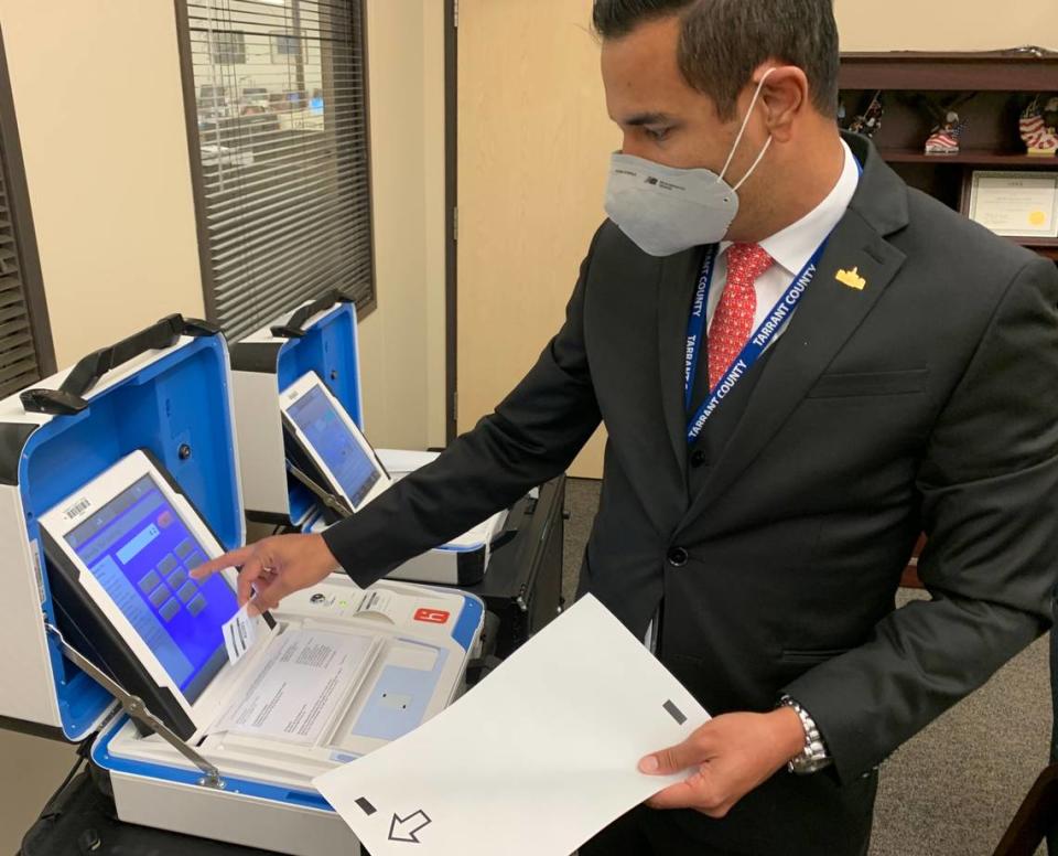 Heider Garcia, Tarrant County election administrator, demonstrates how to use a voting machine.