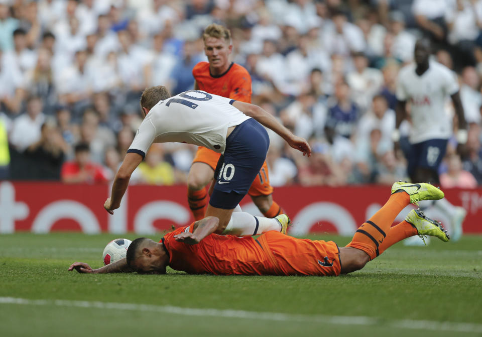 Tottenham's Harry Kane falls after he was tackled by Newcastle's Jamaal Lascelles during the English Premier League soccer match between Tottenham Hotspur and Newcastle United at Tottenham Hotspur Stadium in London, Sunday, Aug. 25, 2019.(AP Photo/Frank Augstein)