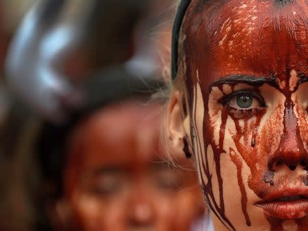 A animal rights protester covered in fake blood demonstrate for the abolition of bull runs and bullfights a day before the start of the famous running of the bulls San Fermin festival in Pamplona, northern Spain, July 5, 2016. REUTERS/Eloy Alonso