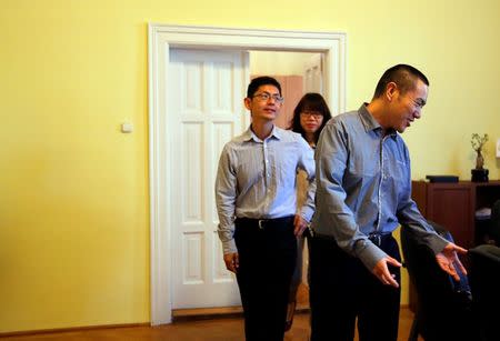 Yan Ding, a Chinese immigrant to Hungary who received an EU residency permit through the purchase of a special 300,000 euro government bond, offers a seat to fellow immigrants and investors in his office in Budapest September 28, 2016. REUTERS/Laszlo Balogh