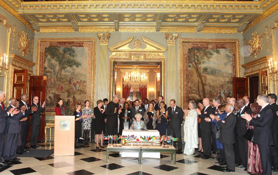 Britain's Queen Elizabeth II, Head of the Commonwealth signs the Commonwealth Charter at a reception at Marlborough House, London, Monday March 11, 2013. The Charter is an historic document which brings together, for the first time in the associations 64-year history, key declarations on Commonwealth principles. (AP Photo/PA, Philip Toscano) UNITED KINGDOM OUT NO SALES NO ARCHIVE