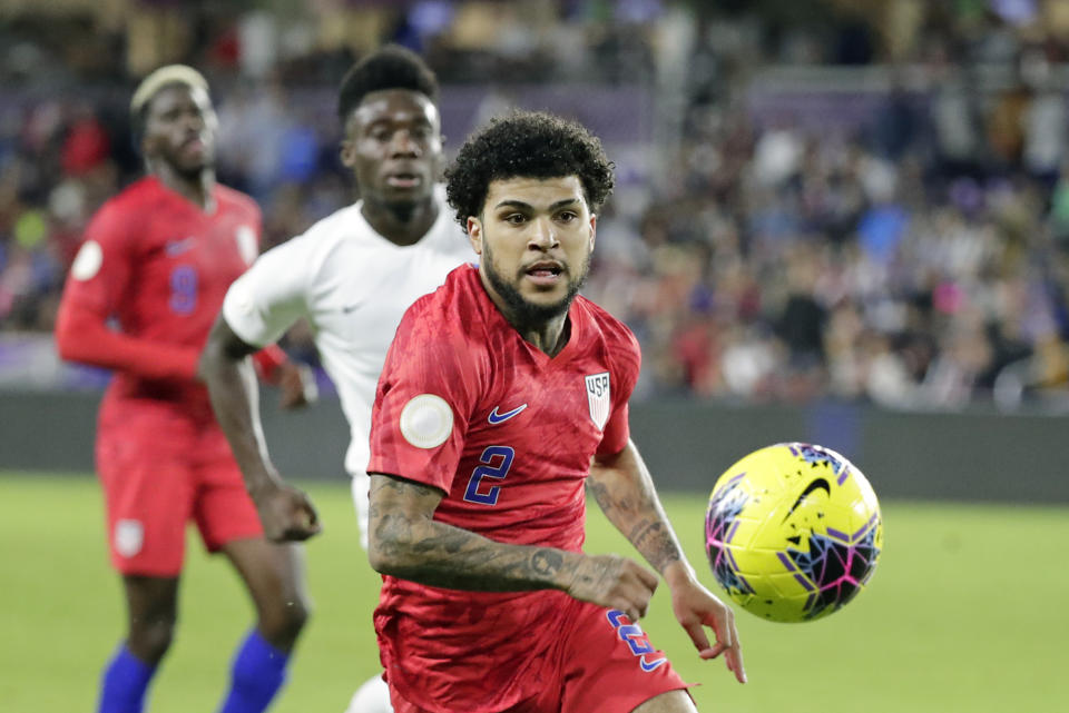 U.S. defender DeAndre Yedlin, right, goes after the ball in front of Canada midfielder Alphonso Davies, center, as forward Gyasi Zardes, left, watches during the second half of a CONCACAF Nations League soccer match Friday, Nov. 15, 2019, in Orlando, Fla. (AP Photo/John Raoux)