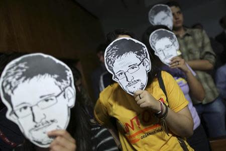 People use masks with pictures of former NSA contractor Edward Snowden masks during the testimonial of Glenn Greenwald, the American journalist who first published the documents leaked by Snowden, before a Brazilian Congressional committee on NSA's surveillance programs, in Brasilia August 6, 2013. REUTERS/Ueslei Marcelino