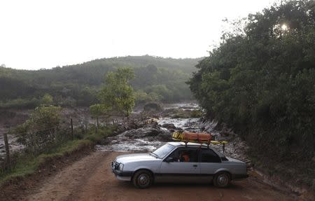 Rescue workers drive on a road blocked with mud after a dam owned by Vale SA and BHP Billiton Ltd burst in Mariana, Brazil, November 6, 2015. REUTERS/Ricardo Moraes