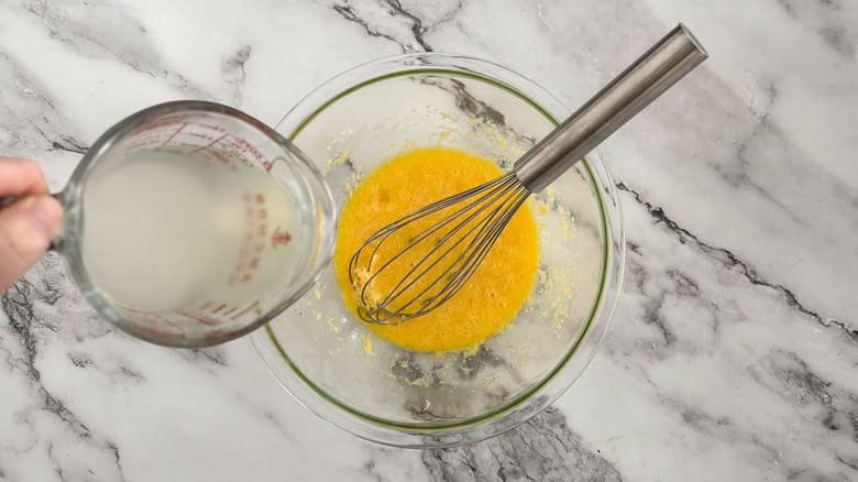 hand pouring water into eggs