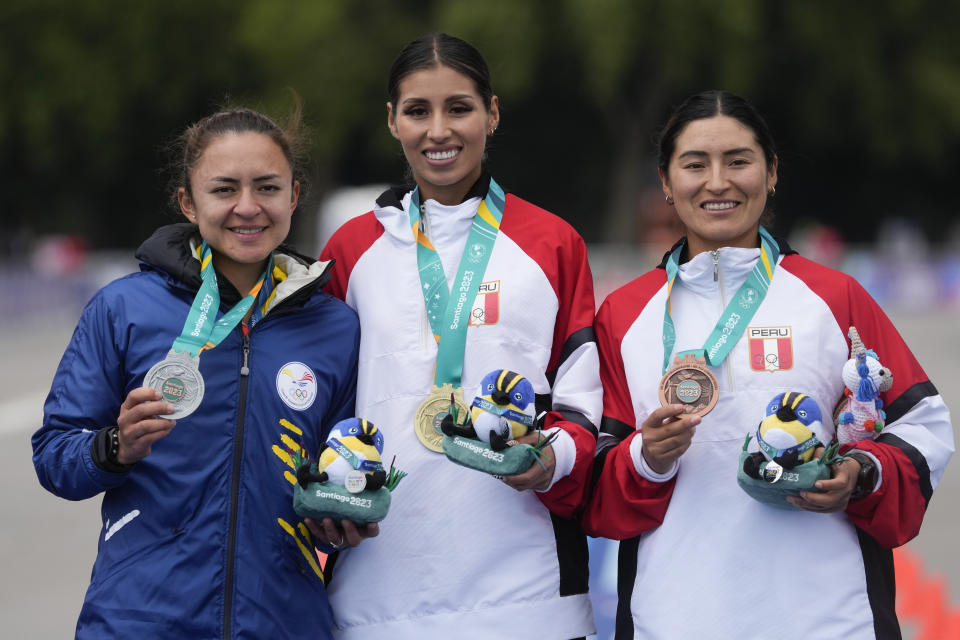 From left, Ecuador's Glenda Morejon, Peru's Gabriela Kimberly Garcia and Peru's Evelyn Inga pose on the podium of the women's 20km race walk at the Pan American Games in Santiago, Chile, Sunday, Oct. 29, 2023. (AP Photo/Moises Castillo)