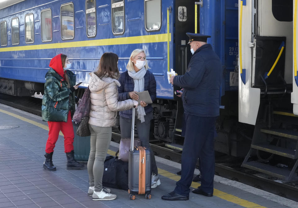 FILE - In this Tuesday, Oct. 26, 2021 file photo, a train conductor checks the Covid Certificate of passengers, at a train station in Kyiv, Ukraine, Ukraine. Ukraine is suffering through a surge in coronavirus infections, along with other parts of Eastern Europe and Russia. While vaccines are plentiful, there is a widespread reluctance to get them in many countries — though notable exceptions include the Baltic nations, Poland, the Czech Republic, Slovenia and Hungary. (AP Photo/Efrem Lukatsky, File)