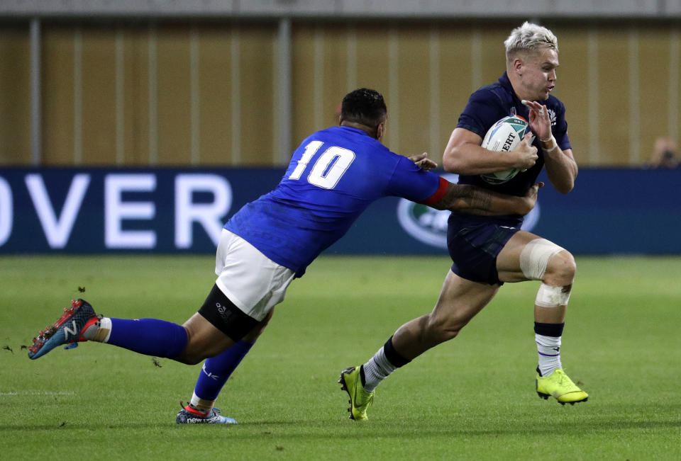 Scotland's Darcy Graham runs past Samoa's Tusi Pisi, left, during the Rugby World Cup Pool A game at Kobe Misaki Stadium between Scotland and Samoa in Kobe City, Japan, Monday, Sept. 30, 2019. (AP Photo/Aaron Favila)