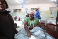 A woman who survived a bus crash receives treatment in Rusape about 170 kilometres east of the capital Harare, Thursday, Nov. 8, 2018. A head-on collision between two buses has killed 47 people, where road accidents are common due to poor roads and bad driving. (AP Photo/Tsvangirayi Mukwazhi)