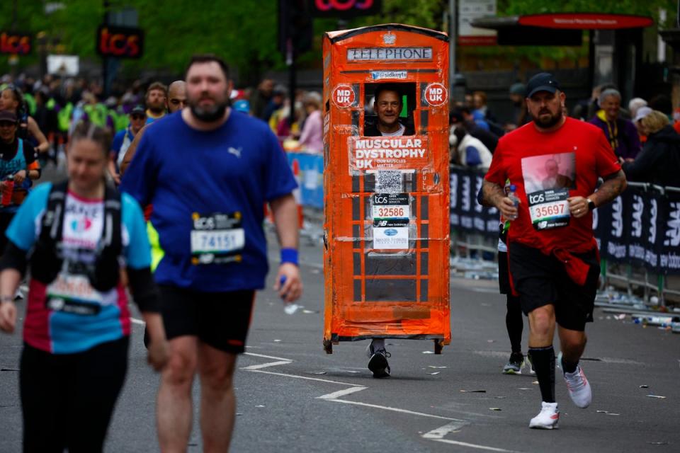 Sid Keyte dressed as a telephone box in action during the marathon (REUTERS)