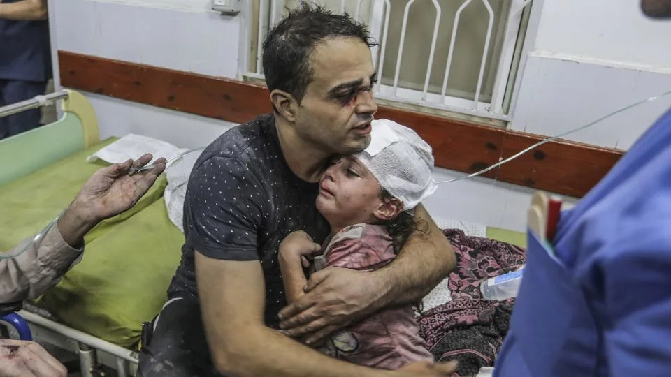 A Palestinian man hugs his wounded child as they receive medical attention at Al-Najjar Hospital, following an Israeli airstrike on Rafah in the southern Gaza Strip, on October 30. - Abed Rahim Khatib/picture-alliance/dpa/AP