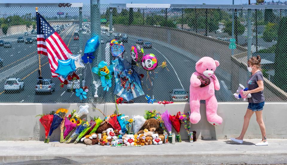 Susan Kellogg brings two stuffed toy animals to a growing memorial on an overpass of the 55 freeway in Orange, California. 6-year-old Aiden Leos was shot and killed during a road-rage attack in late May, authorities say.