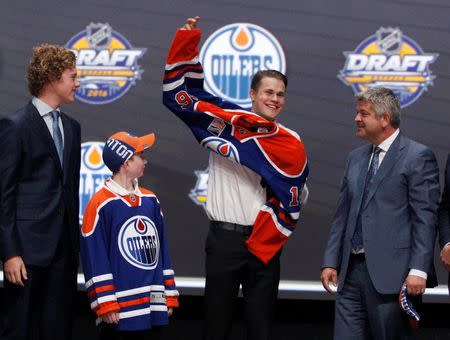 Jun 24, 2016; Buffalo, NY, USA; Jesse Puljujarvi puts on a team jersey after being selected as the number four overall draft pick by the Edmonton Oilers in the first round of the 2016 NHL Draft at the First Niagra Center. Mandatory Credit: Timothy T. Ludwig-USA TODAY Sports