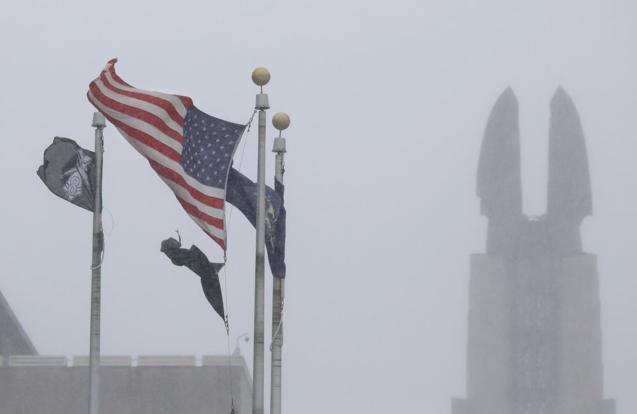Flags whip in the winds outside the Public Safety Building in Rochester Friday, Dec. 23, 2022 as a powerful winter storm front blows into the area bringing frigid temperatures, high winds and lake effect snow.  