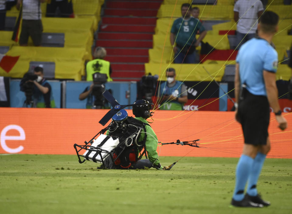 Referee looks as a paraglider lands on the pitch prior the start of the Euro 2020 soccer championship group F match between Germany and France at the Allianz Arena stadium in Munich, Tuesday, June 15, 2021. (Franck Fife/Pool via AP)