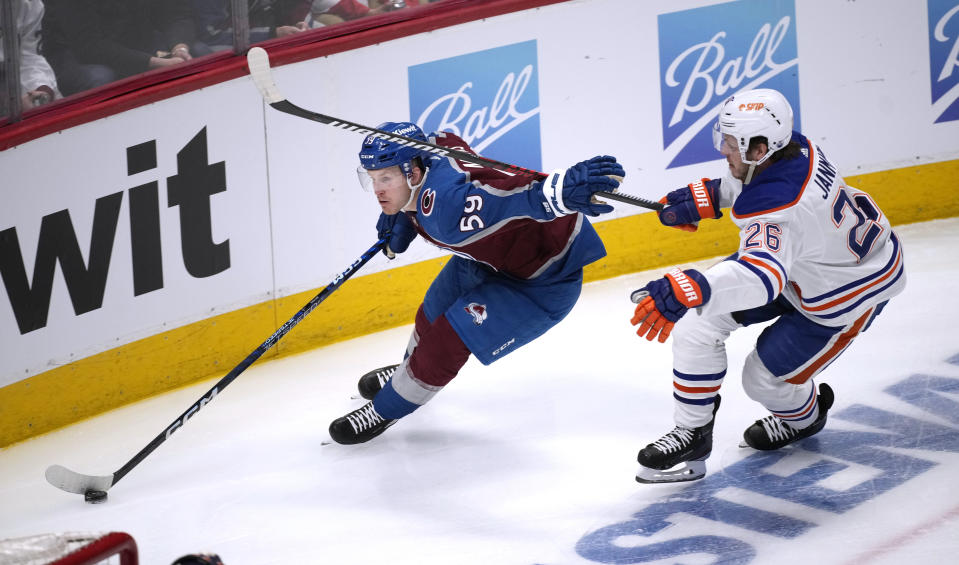 Colorado Avalanche center Ben Meyers, left, drives past Edmonton Oilers center Mattias Janmark during the first period of an NHL hockey game Tuesday, April 11, 2023, in Denver. (AP Photo/David Zalubowski